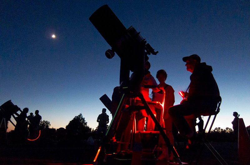 people viewing the moon with telescopes