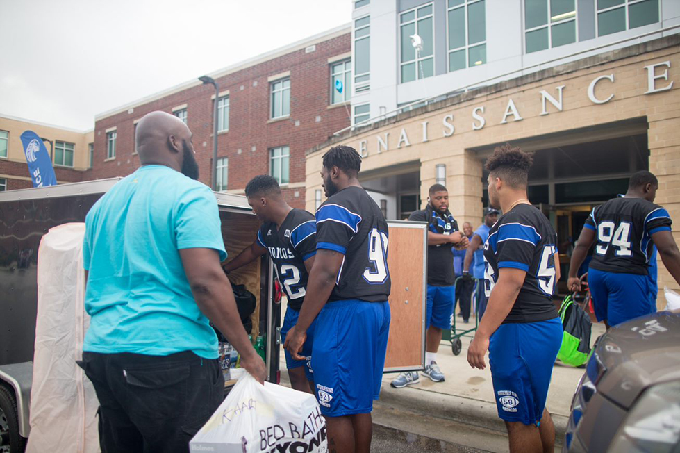 Athletes helps students move in